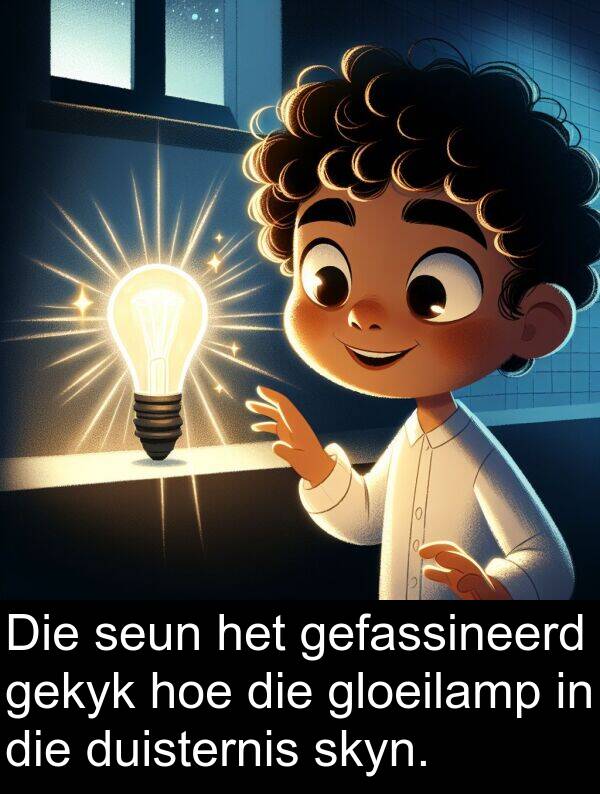 gefassineerd: Die seun het gefassineerd gekyk hoe die gloeilamp in die duisternis skyn.