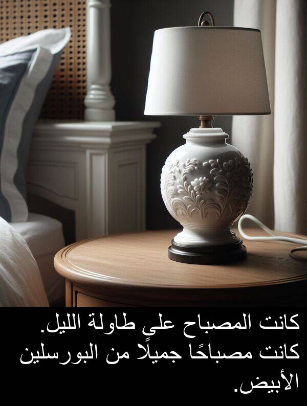 طاولة: كانت المصباح على طاولة الليل. كانت مصباحًا جميلًا من البورسلين الأبيض.