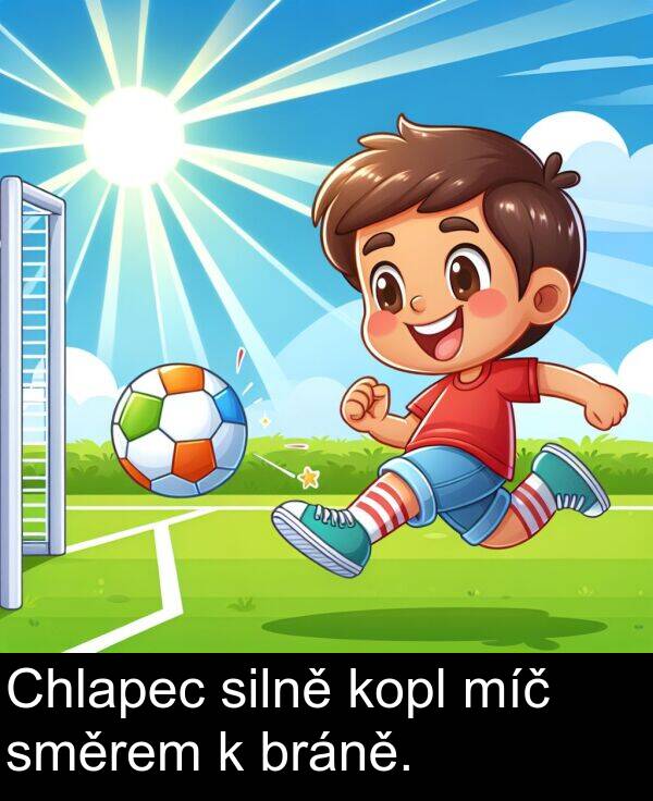 silně: Chlapec silně kopl míč směrem k bráně.
