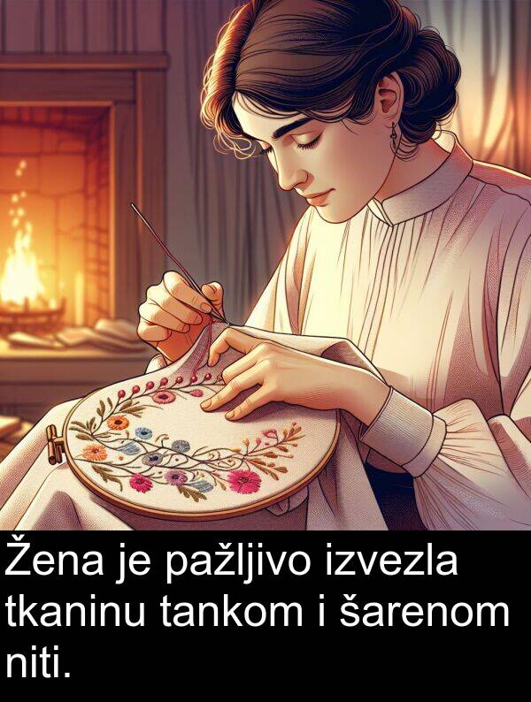 pažljivo: Žena je pažljivo izvezla tkaninu tankom i šarenom niti.