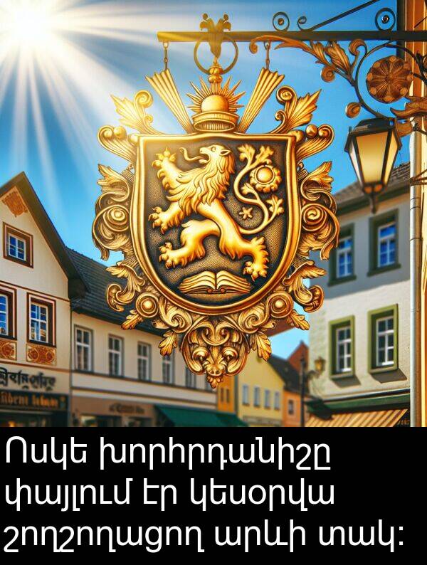 տակ։: Ոսկե խորհրդանիշը փայլում էր կեսօրվա շողշողացող արևի տակ։