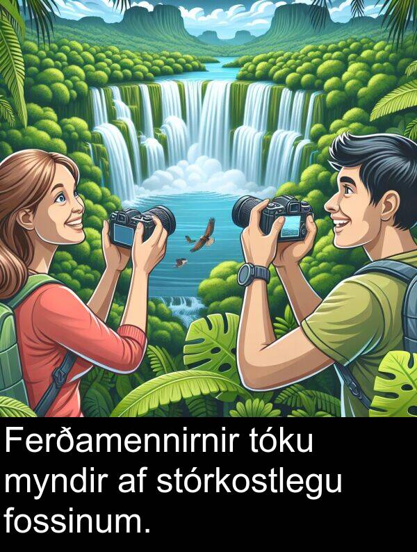 tóku: Ferðamennirnir tóku myndir af stórkostlegu fossinum.