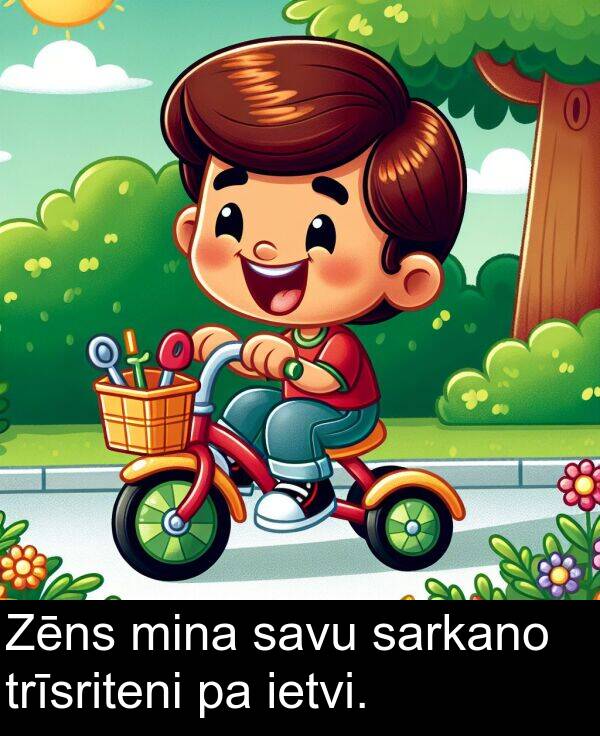 savu: Zēns mina savu sarkano trīsriteni pa ietvi.