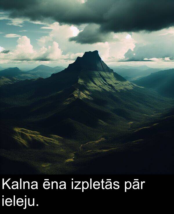 ieleju: Kalna ēna izpletās pār ieleju.