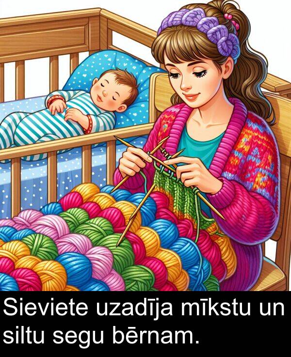 uzadīja: Sieviete uzadīja mīkstu un siltu segu bērnam.