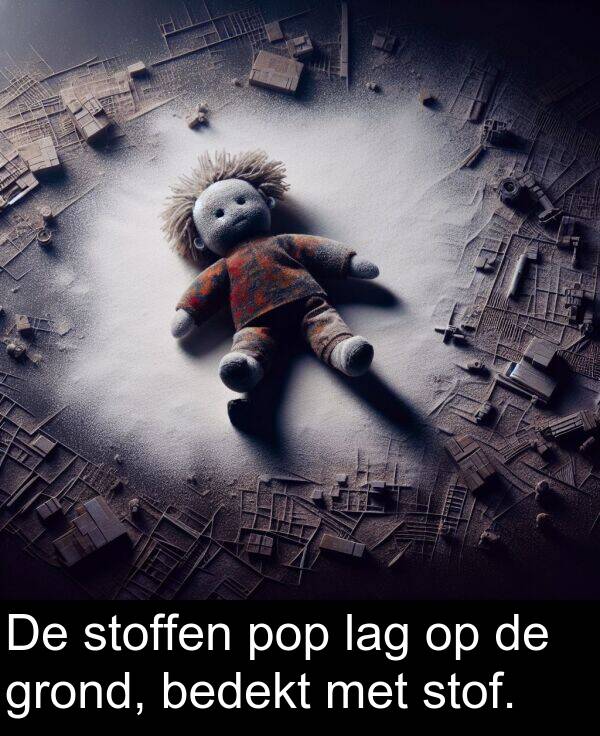 grond: De stoffen pop lag op de grond, bedekt met stof.