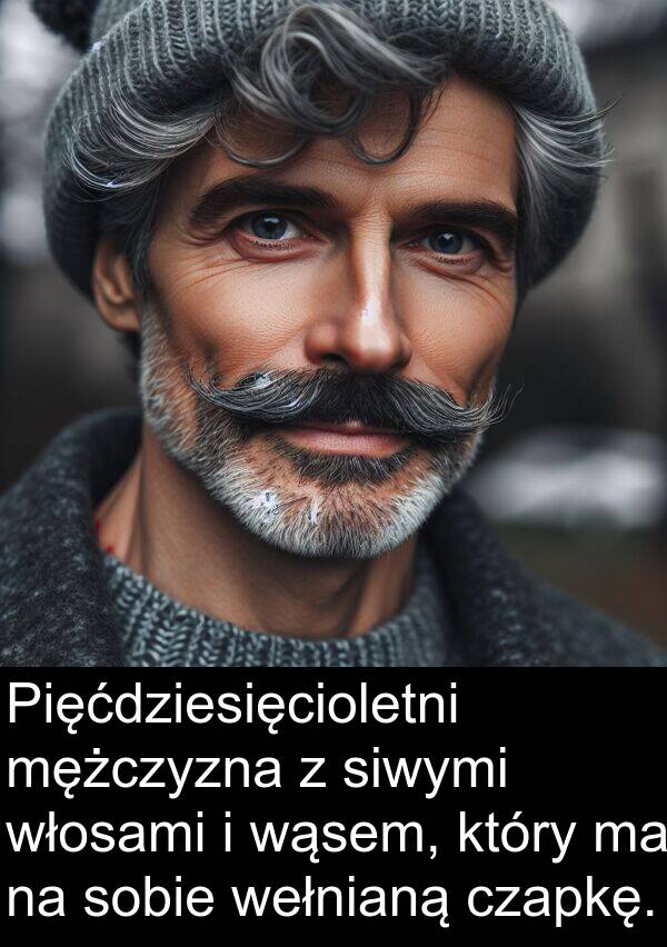 wąsem: Pięćdziesięcioletni mężczyzna z siwymi włosami i wąsem, który ma na sobie wełnianą czapkę.