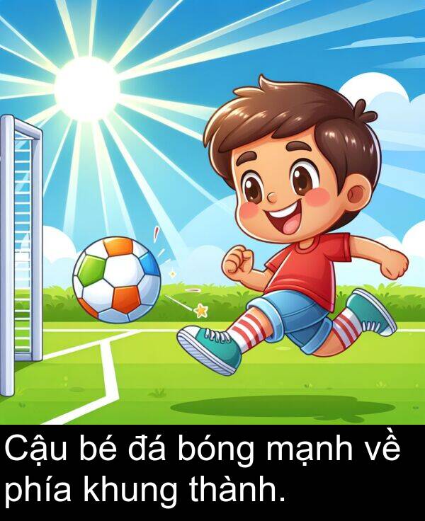 bóng: Cậu bé đá bóng mạnh về phía khung thành.