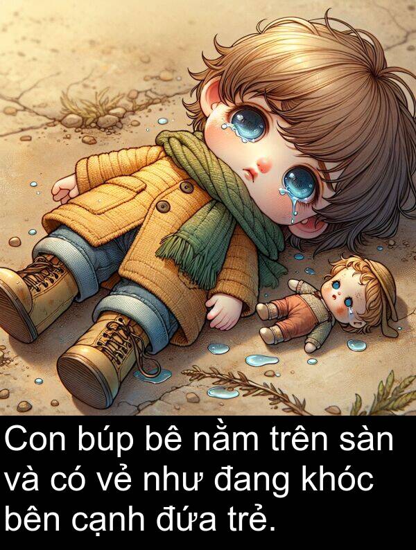 đứa: Con búp bê nằm trên sàn và có vẻ như đang khóc bên cạnh đứa trẻ.